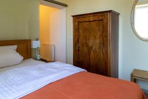 武茨巴赫DK Glasmanufaktur GmbH的一间卧室配有一张床和一个木制橱柜