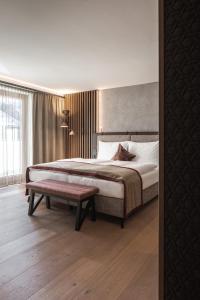 萨尔巴赫萨尔茨堡酒店的一间卧室配有一张大床和一张长凳
