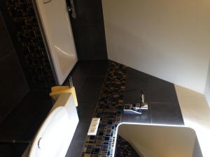 罗滕堡克劳斯叶思图布尔酒店的浴室设有白色水槽和黑色瓷砖地板。