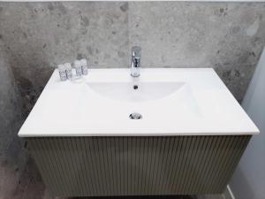 萨拉曼卡Apartamentos Vega by gaiarooms的白色浴室水槽和2瓶水