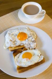 内罗毕Casa Tranquilla - JKIA的盘子,面包上放两个炒鸡蛋,咖啡