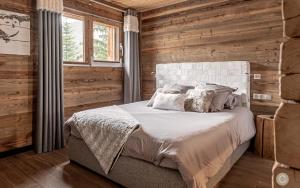 瓦卢瓦尔L'Or des Cimes的卧室配有木墙内的一张床
