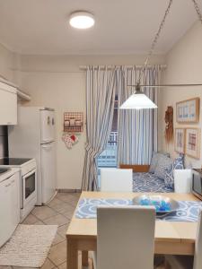 梅塔诺佛希斯Entire Appartment 50m from sea - Spiros的厨房、带桌子的客厅、厨房和用餐室