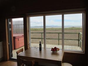 Hjarðarfell兰格弗佳兰度假屋的一张桌子,上面放着一碗水果和一瓶葡萄酒