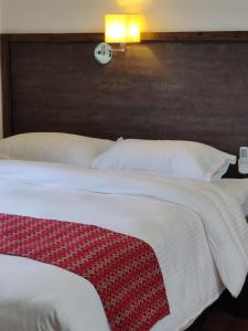 BardiyāBardia Forest Resort的卧室配有一张大床,墙上挂着时钟