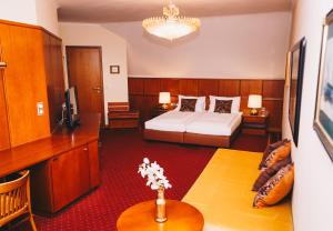 克尼特尔费尔德Paul's Hotel的酒店客房配有一张床铺和一张桌子。