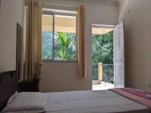 达波林Tangerine Stay - Friends & Family 4BHK Villa, Goa的一间卧室设有一张床和一个大窗户