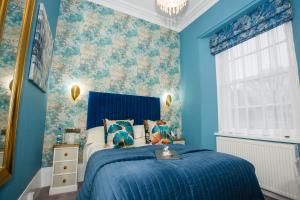 托基克利夫兰2011-2012四星级金奖酒店的一间卧室设有蓝色的墙壁和一张带蓝色床单的床
