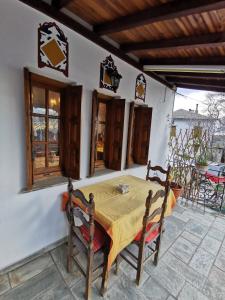 沃洛斯Archontiko Elena的庭院配有桌椅、桌子和窗户