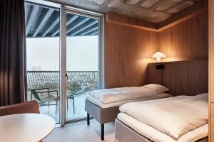 埃斯比约A Place To Hotel Esbjerg的酒店客房设有两张床和一个阳台。