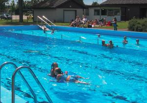 ÄtranÄtrans Stugby & Fritidsanläggning的一群人在游泳池游泳