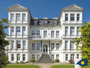 诺伊霍夫Villa Sonnenschein Whg 21的前面有楼梯的大型白色建筑
