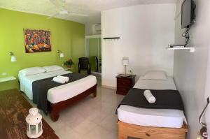佩德纳莱斯Hotel Pedernales Italia Republica Dominicana的酒店客房设有两张床和电视。