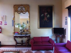 阿亚库乔环球酒店的客厅配有2张红色沙发和镜子