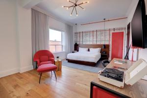 基奇纳The Walper Hotel, part of JdV by Hyatt的酒店客房,配有一张床和一张红色椅子