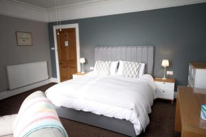 陶因Leahurst Bed and Breakfast的一间卧室配有一张带白色床单的大床