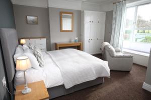 陶因Leahurst Bed and Breakfast的卧室配有床、椅子和窗户。