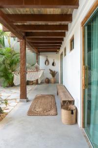 塞古罗港Tropical Beach的门廊配有长凳和吊床