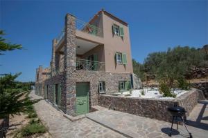 爱琴娜岛Villa Cerise by Upgreat Hospitality的一座带绿门和石墙的房子