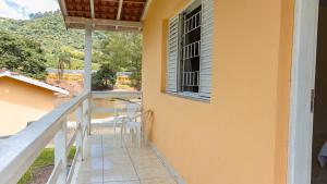 塞拉内格拉Pousada Vale do Ouro Verde的阳台,配有桌椅