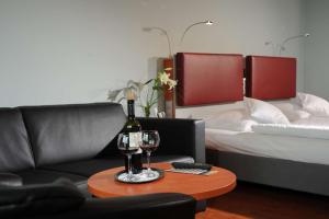 不来梅港Nordsee Hotel Fischereihafen的客厅配有沙发和带葡萄酒玻璃的桌子