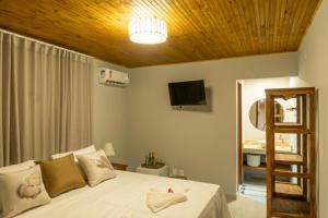 塞古罗港Tropical Beach的卧室配有白色床和木制天花板
