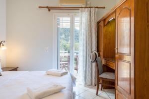阿齐欧斯·贡多斯Sea Breeze Hotel & Apartments的卧室配有床、椅子和窗户。