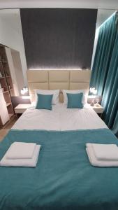 利沃夫DeMar Apart Tiffani的一张配有蓝色和白色床单及枕头的大床