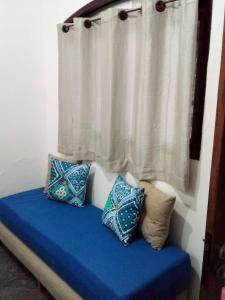 乌巴图巴Excellence Apart的一张带蓝色枕头的床和一个带窗帘的窗户