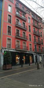 毕尔巴鄂Apartamento Zabala conoce Bilbao desde dentro的城市街道上一座红色的大建筑
