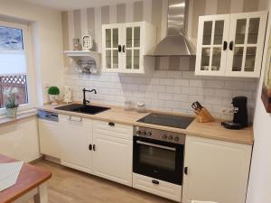 科伯恩-贡多夫朱莉娅乡村别墅酒店的厨房配有白色橱柜和炉灶烤箱。