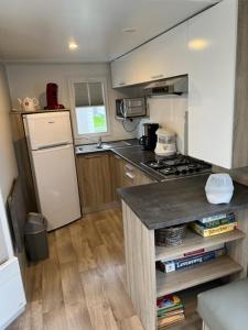 米德尔克尔克Luxe stacaravan的小厨房配有炉灶和冰箱