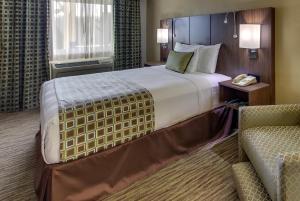 蒙特雷蒙特雷史蒂文森汽车旅馆的酒店客房带一张大床和一把椅子