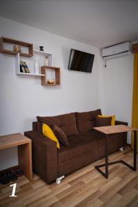 比耶利纳Studio apartmani Emili Bijeljina apartman br 1的客厅配有棕色沙发和桌子