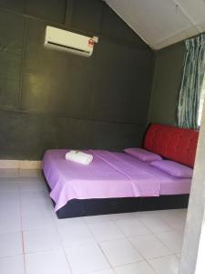 瓜拉大汉Durian Chalet的一间小卧室,房间内设有一张紫色的床