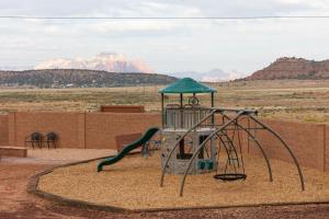 Apple ValleyGooseberry Lodges Zion National Park Area的沙漠中的游乐场,以群山为背景