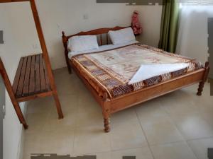 奈瓦沙三人伊甸度假村 - 奈瓦沙的一间卧室配有一张木床和一把椅子