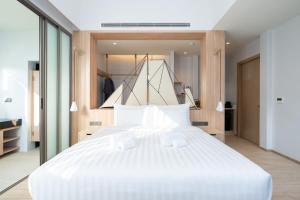 攀瓦海滩Panwaburi Beachfront Resort - SHA Extra Plus的卧室配有一张白色大床