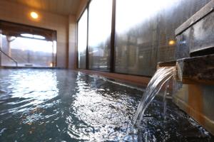 驹根市山吹旅馆的一座建筑物内带喷泉的游泳池