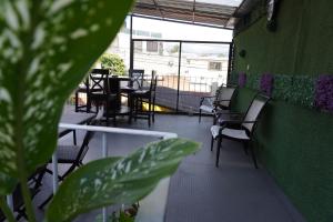 危地马拉Hostal Guatefriends的一间带桌椅和绿色墙壁的餐厅