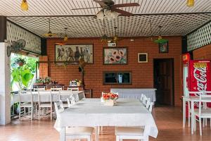Bān Tha Pu Deang班维南野营度假村的餐厅配有白色桌椅和吊扇
