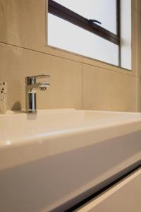 约翰内斯堡Villa Portia的浴室设有白色水槽和镜子