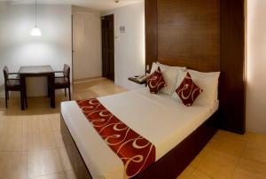 马尼拉ACL套房酒店的酒店客房配有一张床铺和一张桌子。