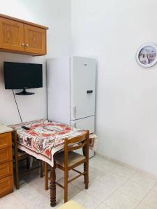 帕罗斯岛fanis sweet home的厨房配有桌子和白色冰箱。