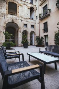 巴勒莫PALAZZO SANTAMARINA Luxury Suite & Spa的一组桌子和长凳在建筑物前