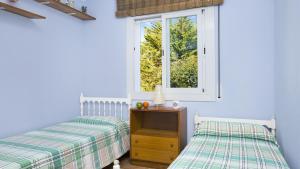 卡莱利亚德帕拉弗鲁赫尔Roc 1D - Calella de Palafrugell的一间卧室设有两张床和窗户。