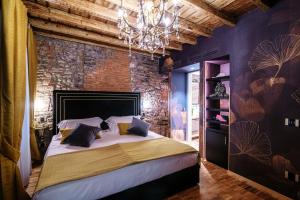 科莫Vitrum - Como Luxury Suites的一间卧室配有一张大床和一个吊灯。