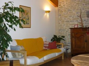Loubens拉布达斯住宿加早餐旅馆的客厅里设有一张黄色的沙发,客厅里设有砖墙