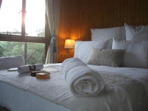 侯斯普瑞特Blyde River Cabins的一张白色的床,上面有毛巾,还有窗户