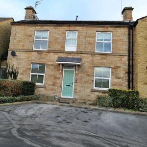 MirfieldApartment 11, Mirfield, West Yorkshire的街上有一扇绿门的砖房